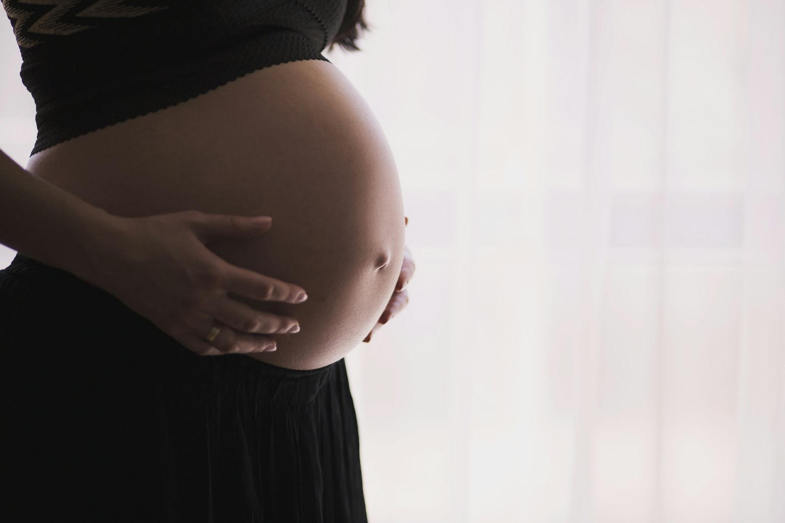 Schwangere Frau hält ihren Bauch